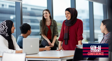 One student standing and speaking with a small group of seated students.